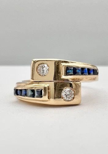 DESIGNER 18K YELLOW GOLD BAGUETTE BLUE SAPPHIRE & DIAMOND CROSSOVER BYPASS RING: DESIGNER 18K YELLOW GOLD BAGUETTE BLUE SAPPHIRE & DIAMOND CROSSOVER BYPASS RING Designer 18K Yellow Gold Baguette Blue Sapphire & Diamond Crossover Bypass Ring Size: 9.25- Can Be Sized Without Damagin