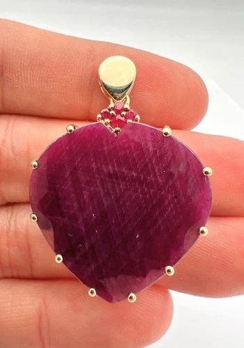 DESIGNER LARGE 40.00CT + HEART SHAPED RUBY 10K YELLOW GOLD PENDANT: DESIGNER LARGE 40.00CT + HEART SHAPED RUBY 10K YELLOW GOLD PENDANT DESCRIPTION Stunning Large Ruby Pendant, set in 10K Yellow Gold. Cent. Ruby Measurements: 30mm x 30mm - 3mm Cent. Ruby Weight: Approx