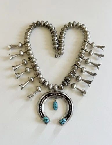 OLD HAND TOOLED NAVAJO COIN SILVER TURQUOISE SQUASH BLOSSOM NECKLACE 116.3G: OLD HAND TOOLED NAVAJO COIN SILVER TURQUOISE SQUASH BLOSSOM NECKLACE 116.3g This Amazing necklace features Gem Quality Blue Spiderweb Turquoise, secure in a Smooth bezel. Necklace has Handmade 12mm Wi