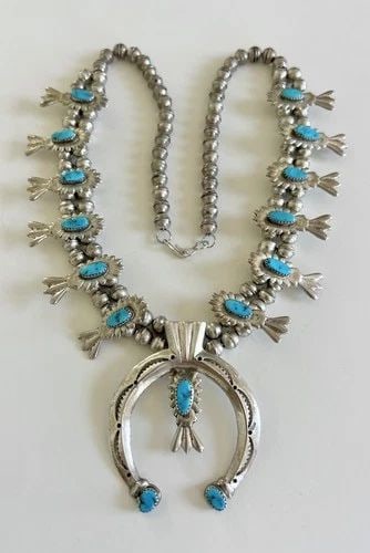 VTG NAVAJO SANDCAST STERLING SLEEPING BEAUTY TURQUOISE SQUASH BLOSSOM NECKLACE: Vtg Navajo Sandcast Sterling Silver Sleeping Beauty Turquoise Squash Blossom Necklace This Amazing necklace features huge specimens of Natural Blue Sleeping beauty Turquoise, secure in a Sawtooth beze