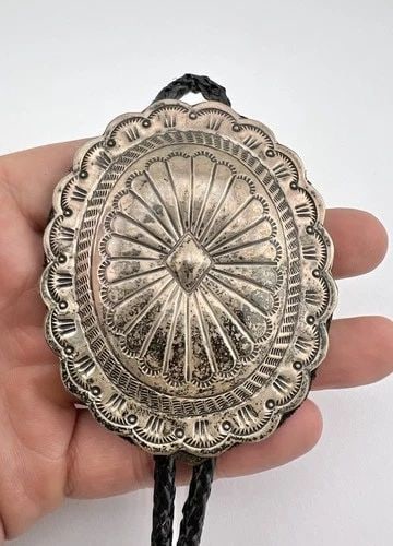 VTG NAVAJO STERLING SILVER DEEP STAMPED OVAL CONCHO BOLO TIE 3 1/8": VTG NAVAJO STERLING SILVER DEEP STAMPED OVAL CONCHO BOLO TIE 3 1/8" Vtg Navajo Sterling Silver Deep Stamped Oval Concho Bolo Tie 3 1/8" Size: 3 1/8" Tall by 2 1/2" Wide Weight is 51.3 Grams on my scal