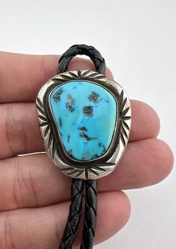 VINTAGE NAVAJO STERLING SILVER SLEEPING BEAUTY TURQUOISE STAMPED BOLO TIE: VINTAGE NAVAJO STERLING SILVER SLEEPING BEAUTY TURQUOISE STAMPED BOLO TIE Vintage Navajo Sterling Silver Sleeping Beauty Turquoise Stamped Bolo Tie Size: 1 3/8" Tall by 1 1/4" Wide Weight is 27.0 Gram