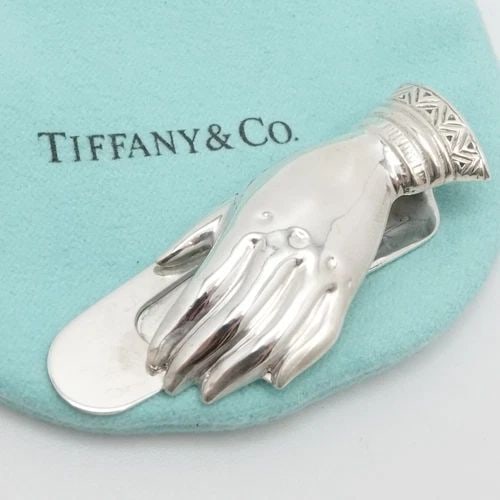 TIFFANY & CO. MAKERS STERLING SILVER HAND MOTIF MONEY CLIP: TIFFANY & CO. MAKERS STERLING SILVER HAND MOTIF MONEY CLIP Vintage Tiffany & Co. Makers Sterling Silver Hand Motif Money/Book Clip Total Length - 2" Width - 3/4" Total Weight - 12.9 Grams Hallmark - T
