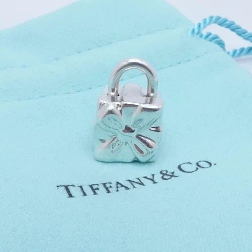 TIFFANY & CO. STERLING SILVER GIFT BOX BOW PADLOCK CHARM: Tiffany & Co. Sterling Silver Gift Box Padlock Charm Height - 0.75" Width - 0.50" Weight - 14.5 Grams Est. Retail - $375 USD Looks Great & Pouch NOT Included