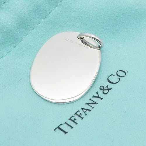 TIFFANY & CO. STERLING SILVER BLANK OVAL TAG PENDANT 1.25": Tiffany & Co. Sterling Silver Blank Oval Tag Pendant ONLY Total Height - 1.25" Pendant Width - 0.75" Depth - 1mm Thick Bail Height - 5mm Bail Width - 4mm Total Weight - 5.8 Grams Pouch NOT Included