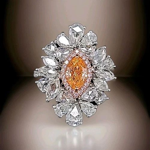18K WHITE GOLD STATEMENT RING 0.85CT.NATURAL FANCY ORANGE DIAMOND MARQUISE CUT: 18K WHITE GOLD STATEMENT RING 0.85CT.NATURAL FANCY ORANGE DIAMOND MARQUISE CUT This stunning 18k white gold ring is a true statement piece. The marquise cut natural fancy orange diamond is the star of