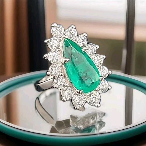 PLATINUM ENGAGEMENT RING 4.57CT. NATURAL GEM GREEN EMERALD PEAR SHAPE: PLATINUM ENGAGEMENT RING 4.57CT. NATURAL GREEN EMERALD PEAR SHAPE This stunning platinum engagement ring features a breathtaking 4.57-carat green emerald in a pear shape. The emerald is a natural crea
