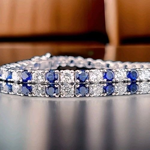 14K WHITE GOLD TENNIS BRACELET 12.52CT. ROUND BLUE SAPPHIRE NATURAL DIAMONDS: 14K WHITE GOLD TENNIS BRACELET 12.52CT. ROUND BLUE SAPPHIRE NATURAL DIAMONDS This 14k White Gold Tennis Bracelet features 12.52ct. Of round blue diffused treated sapphire and natural diamond accents. 