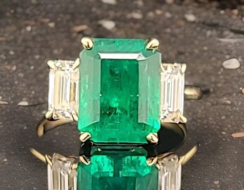 14K YELLOW GOLD ENGAGEMENT THREE-STONE RING 4.18CT. NATURAL GREEN EMERALD: 14K YELLOW GOLD ENGAGEMENT THREE-STONE RING 4.18CT. NATURAL GREEN EMERALD This stunning 14K yellow gold cocktail ring features a beautiful three-stone setting with natural green emeralds and two clean