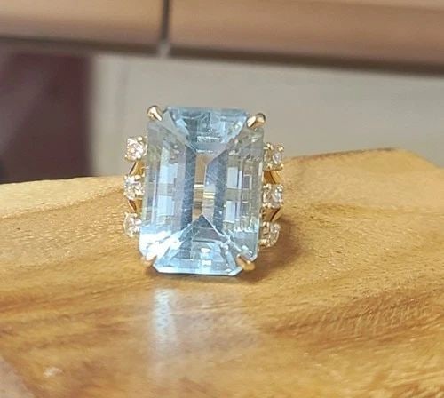 VINTAGE 14K YELLOW GOLD ENGAGEMENT RING 21.56CT.NATURAL AQUAMARINE EMERALD CUT: VINTAGE 14K YELLOW GOLD ENGAGEMENT RING 21.56CT.NATURAL AQUAMARINE EMERALD CUT This breathtaking vintage 14K yellow gold engagement ring is a true statement of timeless elegance, showcasing a magnific