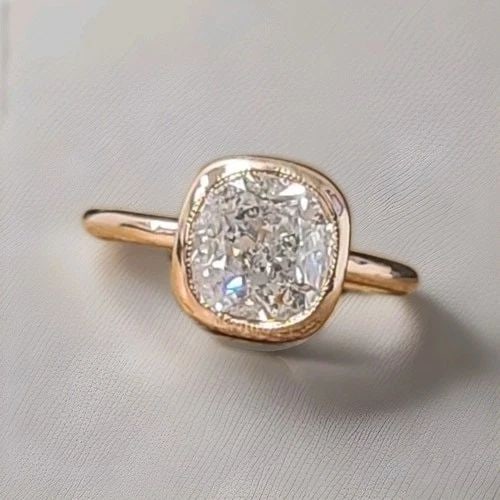 VINTAGE 14K ROSE GOLD ENGAGEMENT BEZEL RING 2.39CT. CUSHION SHAPE DIAMOND: VINTAGE 14K ROSE GOLD ENGAGEMENT BEZEL RING 2.39CT. CUSHION SHAPE DIAMOND Make an unforgettable statement with this breathtaking vintage engagement ring, masterfully crafted in 14K rose gold. At its c