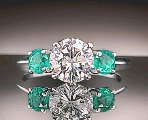 14K WHITE GOLD ENGAGEMENT RING 1.62CT.NATURAL ROUND CUT DIAMOND GREEN EMERALD: 14K WHITE GOLD ENGAGEMENT RING 1.62CT.NATURAL ROUND CUT DIAMOND GREEN EMERALD Elegant 14K white gold three-stone ring showcasing a natural earth-mined round brilliant diamond weighing 1.10 carats. The