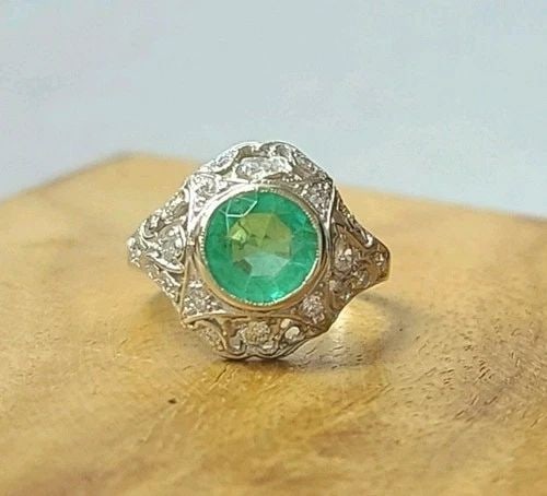 VINTAGE 14K WHITE GOLD ENGAGEMENT RING 1.35CT. NATURAL ROUND COLOMBIAN EMERALD: VINTAGE 14K WHITE GOLD ENGAGEMENT RING 1.35CT. NATURAL ROUND COLOMBIAN EMERALD A romantic treasure from the Art Deco era, this gorgeous vintage engagement ring is crafted in elegant 14K white gold wit