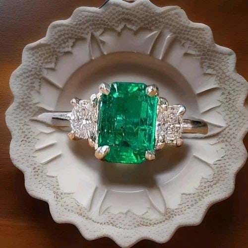 VINTAGE 14K WHITE GOLD ENGAGEMENT RING 1.24CT. NATURAL GREEN EMERALD: VINTAGE 14K WHITE GOLD ENGAGEMENT RING 1.24CT. NATURAL GREEN EMERALD This vintage 14k white gold engagement ring boasts a stunning 1.24ct natural green emerald center stone, flanked by two diamonds. T