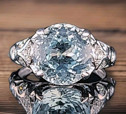 VINTAGE 14K WHITE GOLD ENGAGEMENT RING 7.61CT. NATURAL SKY BLUE AQUAMARINE ROUND: VINTAGE 14K WHITE GOLD ENGAGEMENT RING 7.61CT. NATURAL SKY BLUE AQUAMARINE ROUND This vintage 14K white gold engagement ring features a stunning natural sky blue aquamarine round stone with a total ca
