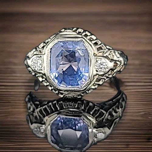 VINTAGE 18K WHITE GOLD ENGAGEMENT RING 1.64CT. NATURAL BLUE SAPPHIRE CUSHION: VINTAGE 18K WHITE GOLD ENGAGEMENT RING 1.64CT. NATURAL BLUE SAPPHIRE CUSHION This vintage 18K white gold engagement ring features a stunning 1.64 carat cushion-cut blue sapphire gemstone, which is set
