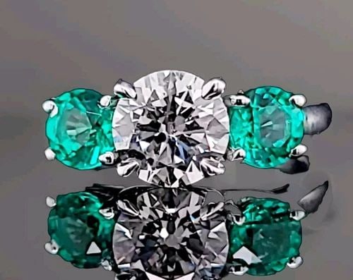 VINTAGE PLATINUM THREE STONES ENGAGEMENT RING 2.19CT DIAMOND GREEN EMERALD: VINTAGE PLATINUM THREE STONES ENGAGEMENT RING 2.19CT DIAMOND GREEN EMERALD This vintage platinum three-stone engagement ring features a dazzling 1.29ct lab-grown diamond in a round shape, surrounded b