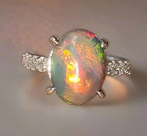 VINTAGE PLATINUM ENGAGEMENT RING 5.45CT. NATURAL ETHIOPIAN OPAL OVAL SHAPE: VINTAGE PLATINUM ENGAGEMENT RING 5.45CT. NATURAL ETHIOPIAN OPAL OVAL SHAPE This exceptional vintage engagement ring is crafted in solid platinum and showcases a magnificent natural Ethiopian opal cabo