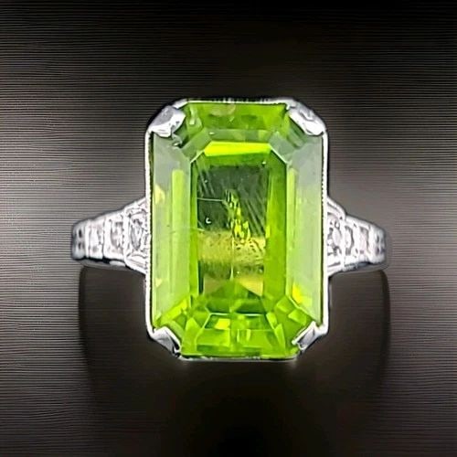 VINTAGE 14K WHITE GOLD ENGAGEMENT RING 7.14CT. NATURAL GREEN PERIDOT RECTANGULAR: VINTAGE 14K WHITE GOLD ENGAGEMENT RING 7.14CT. NATURAL GREEN PERIDOT RECTANGULAR This vintage 14k white gold engagement ring is a stunning piece of fine jewelry. The rectangular main stone is a 7.14CT