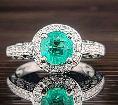 VINTAGE 18K WHITE GOLD ENGAGEMENT RING 1.02CT. ROUND GEM GREEN EMERALD: VINTAGE 18K WHITE GOLD ENGAGEMENT RING 1.02CT. ROUND GEM GREEN EMERALD This vintage engagement ring boasts a beautiful 1.02ct round green gemstone set in 18k white gold. The prong setting style holds 