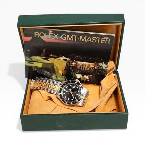 W/BOX ROLEX GMT MASTER 40 MM TWO TONE BLACK AUTOMATIC WATCH 16753 CIRCA 1979: W/BOX ROLEX GMT MASTER 40 MM TWO TONE BLACK AUTOMATIC WATCH Manufacturer Rolex Category GMT Master Subcategory Plastic Crystal Reference Number 16753 Band Steel ,Yellow Gold Band Color Yellow Gold & S