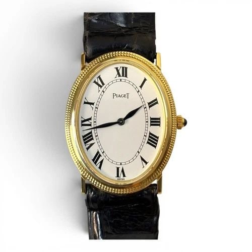 PIAGET CLASSIC LADIES 25 X 32 MM 18K YELLOW GOLD OVAL LEATHER WATCH 9864: PIAGET CLASSIC LADIES 25 X 32 MM 18K YELLOW GOLD OVAL LEATHER WATCH 9864 Manufacturer Piaget Category Classic Reference Number 9864 Band Type Leather Bezel Milled Bezel Box No Case Mes 25 x 32 mm Case