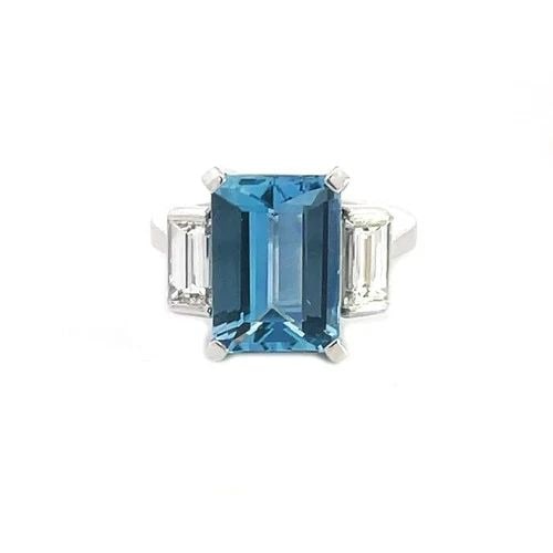 71007 AQUAMARINE DIAMOND RING PLATINUM EMERALD CUT 3 STONE DESIGN: This stunning cocktail ring features a rectangular emerald-cut aquamarine as the main stone, accented by two white smaller emerald cut diamonds on each side. The ring is crafted with platinum and has 