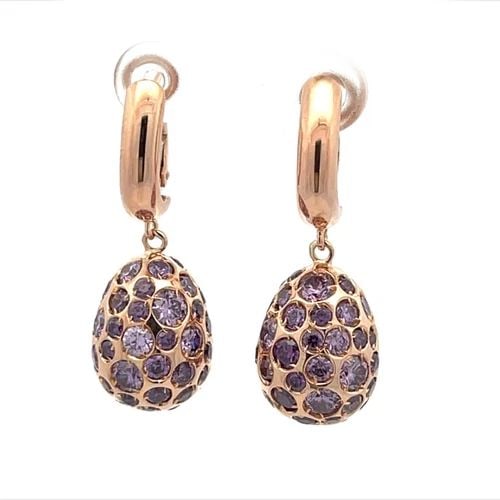 EARRINGS WITH PURPLE GEMSTONES 18K ROSE GOLD OVAL SHAPE DANGLE: EARRINGS WITH PURPLE GEMSTONES 18K ROSE GOLD OVAL SHAPE DANGLE The product is a pair of 18k rose gold oval shaped dangle earrings featuring purple gemstones. The earrings are set in a prong setting an