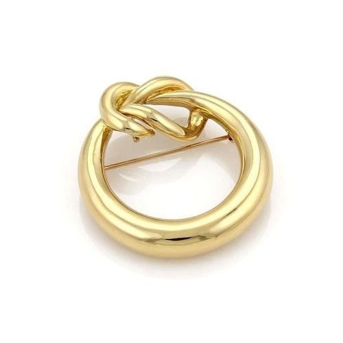 TIFFANY & CO. GOLD PENDANT/PIN 18K YELLOW OPEN CIRCLE LOVE KNOT: TIFFANY & CO. GOLD PENDANT/PIN 18K YELLOW OPEN CIRCLE LOVE KNOT This product is a vintage Tiffany & Co. gold pendant and pin made of 18k yellow gold with an open circle shape and love knot design. It 