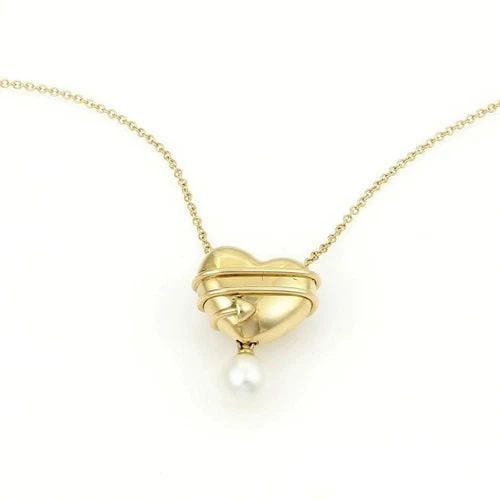 TIFFANY & CO. HEART GOLD NECKLACE PEARL & 18KT YELLOW GOLD CUPID'S ARROW: TIFFANY & CO. HEART GOLD NECKLACE PEARL & 18KT YELLOW GOLD CUPID'S ARROW The Tiffany & Co. Cupid's Arrow Heart necklace is crafted from 18k yellow gold featuring a single pearl dangling from the penda