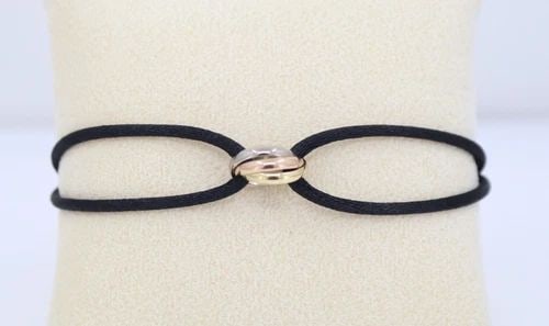 CARTIER TRINITY 18K TRI GOLD ON BLACK SILK CORD BRACELET W/ POUCH FITS 6" TO 8": CARTIER TRINITY 18K TRI GOLD ON BLACK SILK CORD BRACELET W/ POUCH FITS 6" TO 8" Description Cartier Trinity 18k White, Rose & Yellow Gold Silk Cord Bracelet W/ Pouch Item is in excellent condition. Ma