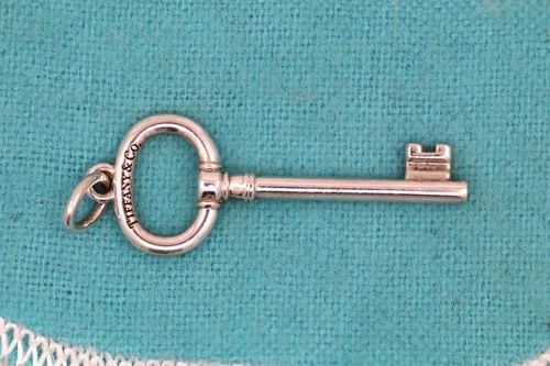 TIFFANY & CO. STERLING SILVER OVAL KEY PENDANT CHARM 1.5" W/ POUCH: TIFFANY & CO. STERLING SILVER OVAL KEY PENDANT CHARM 1.5" W/ POUCH Description Tiffany & Co. Sterling Silver Oval Key Pendant Charm 1.5" w/ Pouch Item is in good condition. May show signs of wear and/