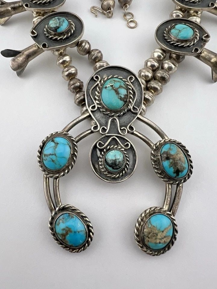 VTG NAVAJO STERLING SILVER WEB KINGMAN TURQUOISE SQUASH BLOSSOM NECKLACE 184.6G: VTG NAVAJO STERLING SILVER WEB KINGMAN TURQUOISE SQUASH BLOSSOM NECKLACE 184.6G Vtg Navajo Sterling Silver Web Kingman Turquoise Squash Blossom Necklace 184.6g This Amazing necklace features huge spec