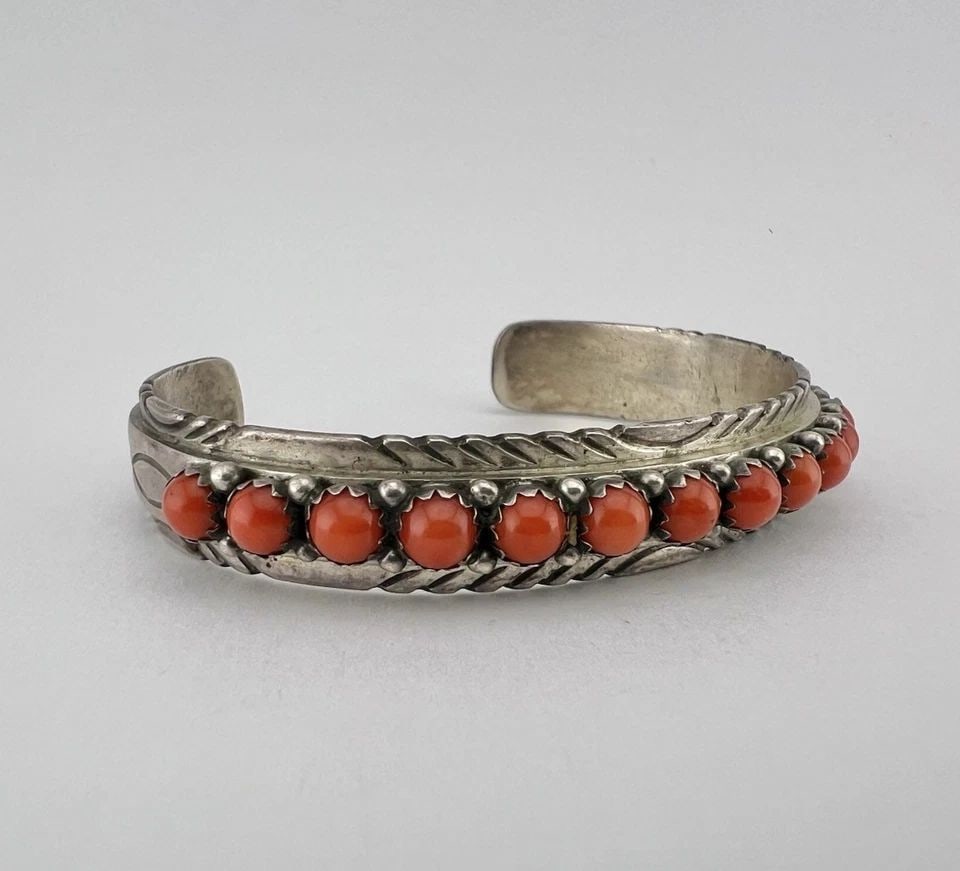 LORENZO JAMES NAVAJO STERLING SILVER RED CORAL STAMPED ROW CUFF BRACELET: LORENZO JAMES NAVAJO STERLING SILVER RED CORAL STAMPED ROW CUFF BRACELET Vtg Lorenzo James Navajo Sterling Silver Red Coral Stamped Row Cuff Bracelet Cuff is 5 7/8" tip to Tip and has a 1 1/8" Wide Ad