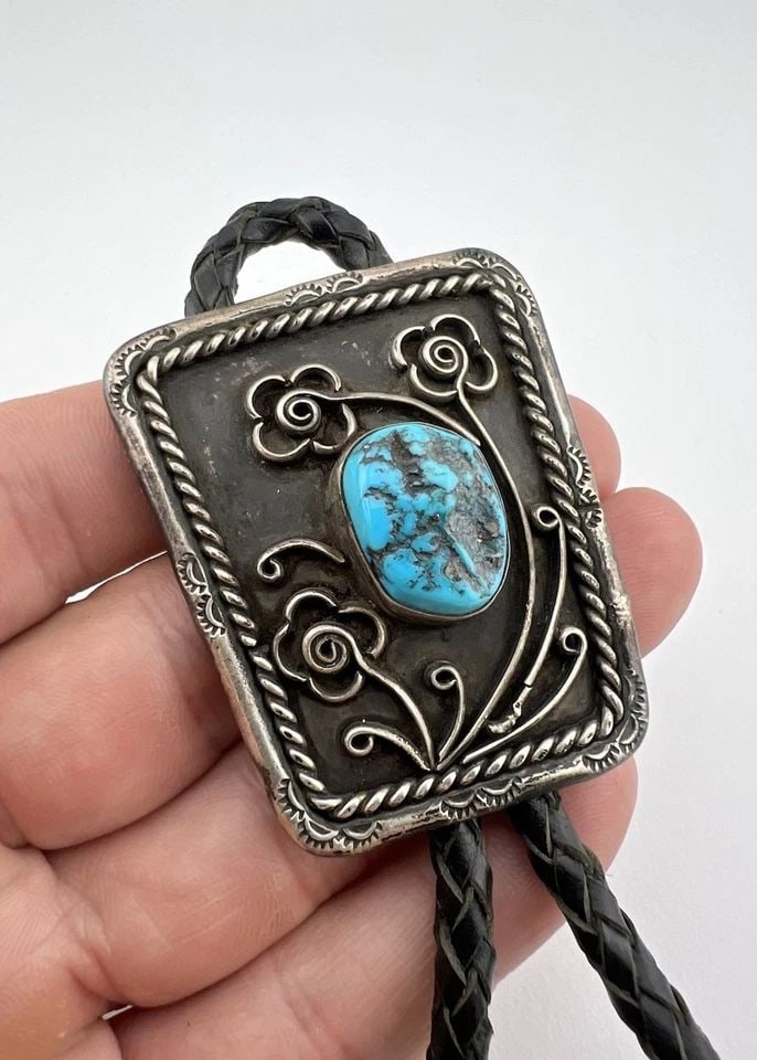 VTG NAVAJO STERLING SILVER SLEEPING BEAUTY TURQUOISE STAMPED FLOWERS BOLO TIE: VTG NAVAJO STERLING SILVER SLEEPING BEAUTY TURQUOISE STAMPED FLOWERS BOLO TIE Vtg Navajo Sterling Silver Sleeping Beauty Turquoise Stamped Flowers Bolo Tie Size: 2 1/8" Tall by 1 3/4" Wide Weight is 4