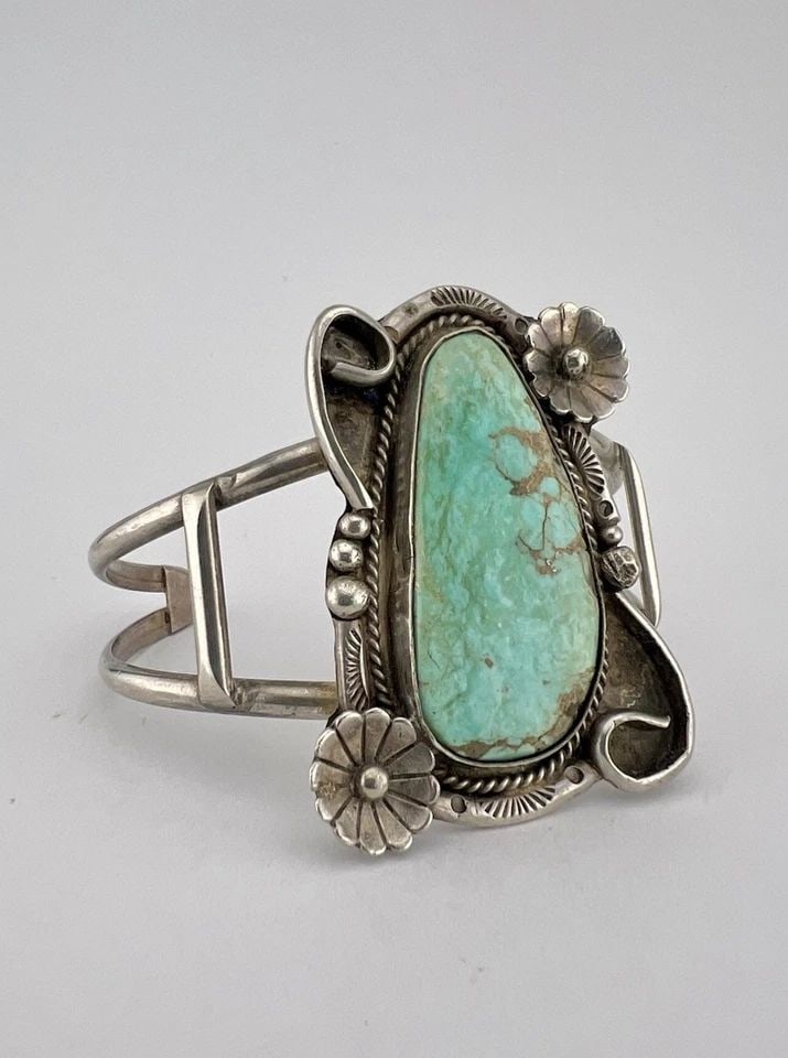 VTG NAVAJO STERLING SILVER HIGH GRADE TURQUOISE STAMPED FLOWER CUFF BRACELET: Vtg Navajo Sterling Silver High Grade Turquoise Stamped Flower Cuff Bracelet Cuff is 5" tip to Tip and has a 1 1/4" Wide Adjustable Gap Cuff Is 1 7/8" Wide In the Center Weight is 30.5 Grams on my sca