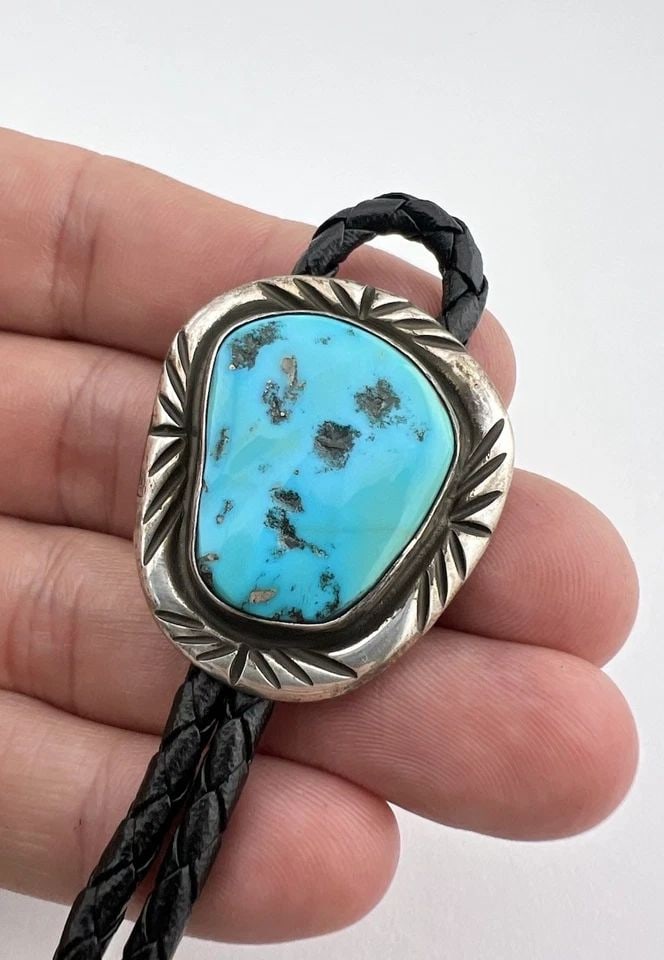 VINTAGE NAVAJO STERLING SILVER SLEEPING BEAUTY TURQUOISE STAMPED BOLO TIE: VINTAGE NAVAJO STERLING SILVER SLEEPING BEAUTY TURQUOISE STAMPED BOLO TIE Vintage Navajo Sterling Silver Sleeping Beauty Turquoise Stamped Bolo Tie Size: 1 3/8" Tall by 1 1/4" Wide Weight is 27.0 Gram