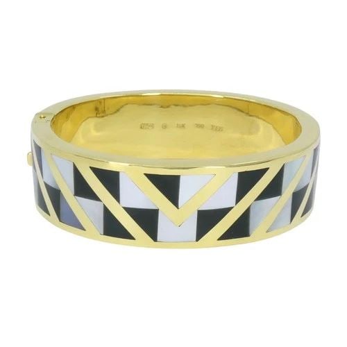 ANGELA CUMMINGS TIFFANY & CO. 1986 18K GOLD ONYX MOTHER OF PEARL INLAY BRACELET: ANGELA CUMMINGS TIFFANY & CO. 1986 18K GOLD ONYX MOTHER OF PEARL INLAY BRACELET KL JUTOO This Angela Cummings for Tiffany & Co. bangle bracelet is a striking 1986 design crafted in 18k yellow gold wit