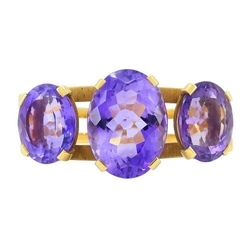 VINTAGE HERMÈS 18K GOLD AMETHYST CLAMPER BRACELET: VINTAGE HERMÈS 18K GOLD AMETHYST CLAMPER BRACELET A striking vintage Hermès cuff bracelet crafted in 18K yellow gold, showcasing three vivid oval-cut amethysts in beautifully balanced prong settings
