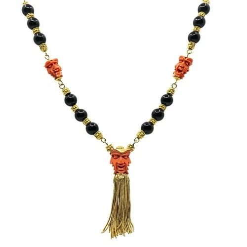 VINTAGE 18K GOLD CARVED CORAL DEVIL MASK ONYX TASSEL NECKLACE: VINTAGE 18K GOLD CARVED CORAL DEVIL MASK ONYX TASSEL NECKLACE CIRCA 1970’s MATERIALS 18k Yellow Gold GEMSTONE Coral, Onyx WEIGHT 132.5 Grams MEASUREMENTS 32” x 3/8” ITEM DETAILS Vintage 