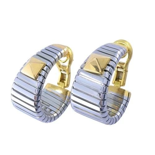 BVLGARI 18K YELLOW GOLD & STEEL TUBOGAS PYRAMID HOOP EARRINGS: BVLGARI 18K YELLOW GOLD & STEEL TUBOGAS PYRAMID HOOP EARRINGS ES AEOO Product details: DESIGNER: Bvlgari CIRCA: 1990s MATERIALS: Steel & 18k Gold WEIGHT: 33.8 Grams MEASUREMENTS: 1” x 1/2”