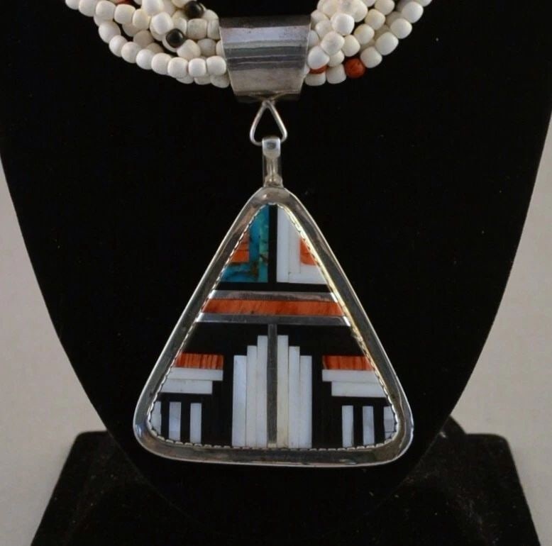 DELBERT CHATTER - LG NAVAJO 9 STRAND CORAL NECKLACE - INLAID PENDANT - 24" - 28": DELBERT CHATTER - LG NAVAJO 9 STRAND CORAL NECKLACE - INLAID PENDANT - 24" - 28" This extraordinary pendant necklace has been crafted by Navajo silversmith Delbert Chatter. The large triangular sterli