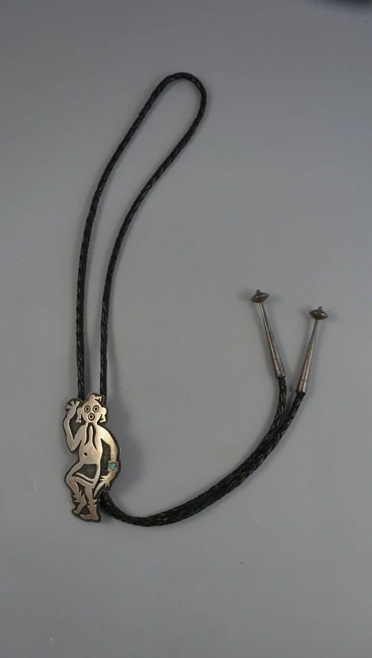 LARRY POLIVEMA - VINTAGE HOPI INDIAN SILVER BOLO TIE - MUDHEAD WITH TURQUOISE: LARRY POLIVEMA - VINTAGE HOPI INDIAN SILVER BOLO TIE - MUDHEAD WITH TURQUOISE This vintage sterling silver bolo tie has been beautifully crafted by Hopi silversmith Larry Polivema. It shows a Mudhead 