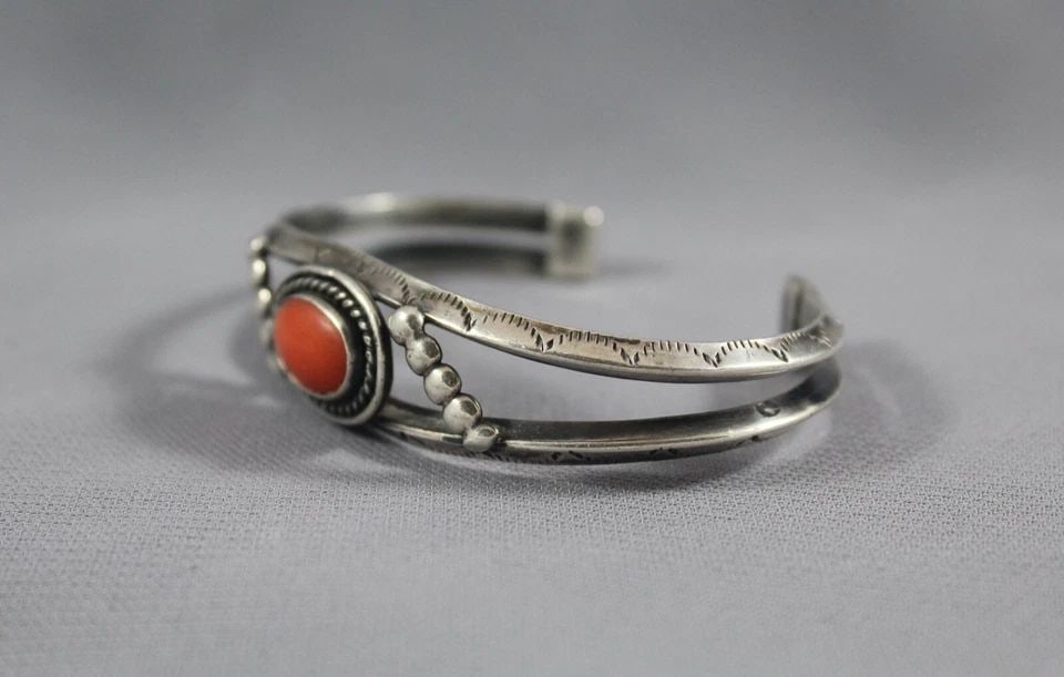 OLD PAWN NAVAJO STERLING SILVER AND CORAL BRACELET: OLD PAWN NAVAJO STERLING SILVER AND CORAL BRACELET Item Description: This bracelet measures 1/2 " wide at the center front. The size is 5" around the inside with an additional 1 1/4" opening at the ba