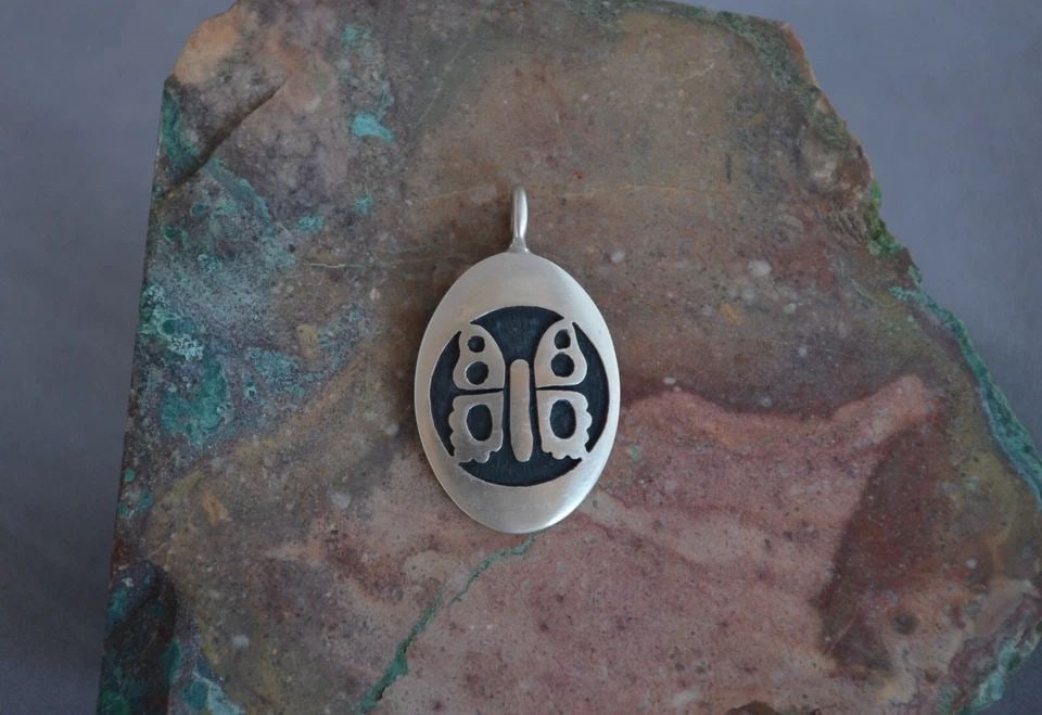 MANUEL HOYUNGOWA (1953-2011 - HOPI STERLING SILVER OVAL PENDANT BUTTERFLY - 1.5": MANUEL HOYUNGOWA (1953-2011 - HOPI STERLING SILVER OVAL PENDANT BUTTERFLY - 1.5" This sterling silver pendant has been beautifully crafted by the Hopi artists Manuel and Karen Hoyungwa. The pendant sh