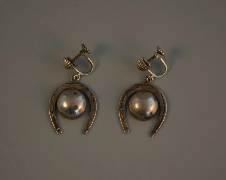 GREAT MEXICAN SILVER EARRINGS DANGLE HORSESHOES - SCREWBACK CLASP - 1 1/2" DROP: GREAT MEXICAN SILVER EARRINGS DANGLE HORSESHOES - SCREWBACK CLASP - 1 1/2" DROP Item Description: This pair of early Mexican silver earrings have a 1 1/2" drop with the vintage screwback type clasps. 