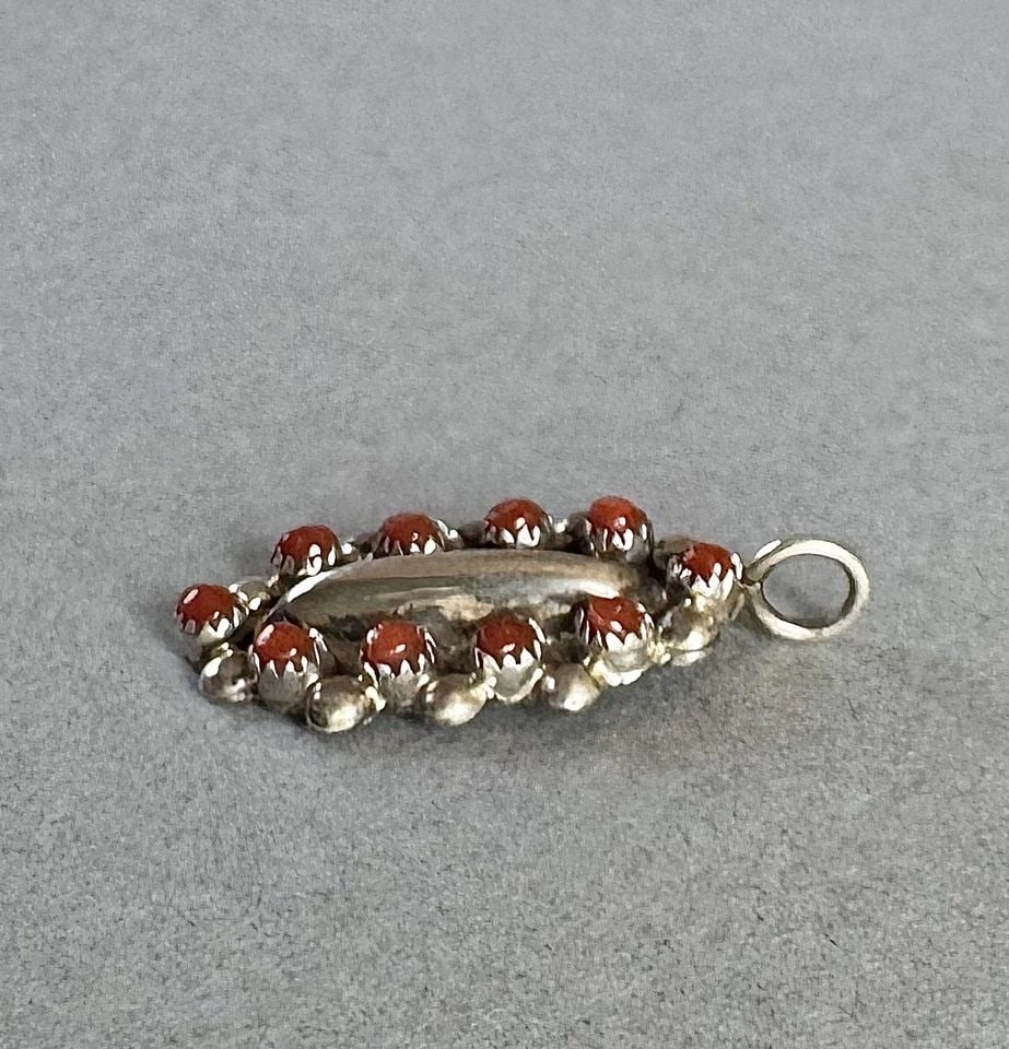 ZUNI SMALL STERLING SILVER AND CORAL PENDANT 7/8 " SIGNED GDM: 7/8 " tall 1.5 Grams Throughout the 40 years that I have been in business, I have purchased jewelry from pawn shops throughout the Southwest that had collections of dead pawn. Most of these pawn shops