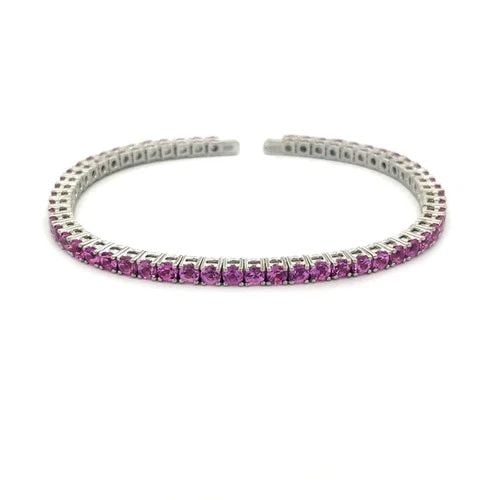 GOLD PINK SAPPHIRE BRACELET 18K WHITE FLEXIBLE TENNIS STYLE BAND: GOLD PINK SAPPHIRE BRACELET 18K WHITE FLEXIBLE TENNIS STYLE BAND This lovely bracelet features stunning pink sapphire in prong setting on 18k white gold flexible tennis style band. The gemstones have 