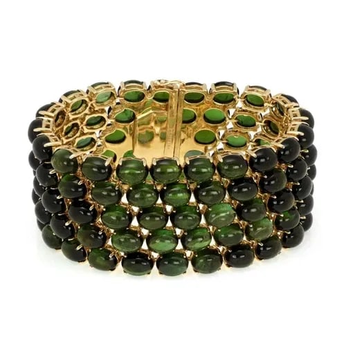 STUNNING 315 CARATS OVAL GREEN TOURMALINE 18K YELLOW GOLD WIDE BRACELET: STUNNING 315 CARATS OVAL GREEN TOURMALINE 18K YELLOW GOLD WIDE BRACELET Stunning 315 Carats Oval Green Tourmaline 18k Yellow Gold Wide Bracelet Description This magnificent Estate bracelet is crafted 