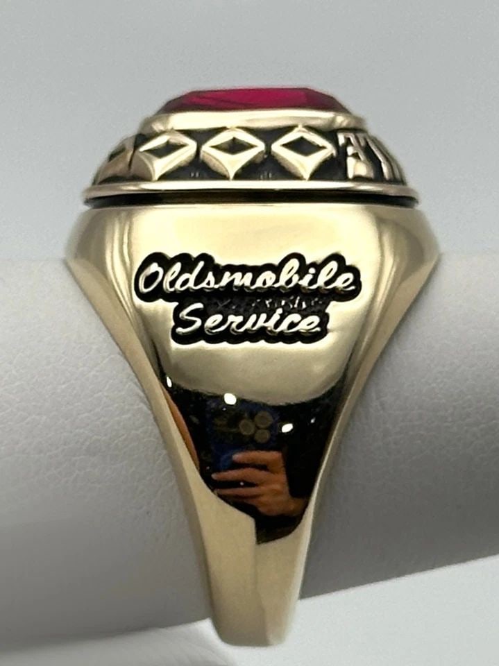 10K GOLD OLDSMOBILE SERVICE RING WITH LAB CREATED RUBY (SIZE 10) 22.6 GRAM: 10k Yellow Gold Oldsmobile Service Ring with Lab Created Ruby Condition: Used, has marks and scratches on it from being moved around in inventory. Has been cleaned and lightly polished Material: 10k Y